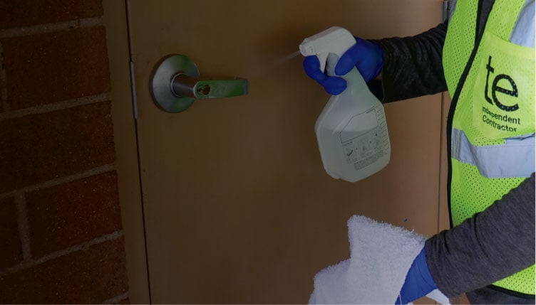 TaskEasy contractor sanitizing a door knob